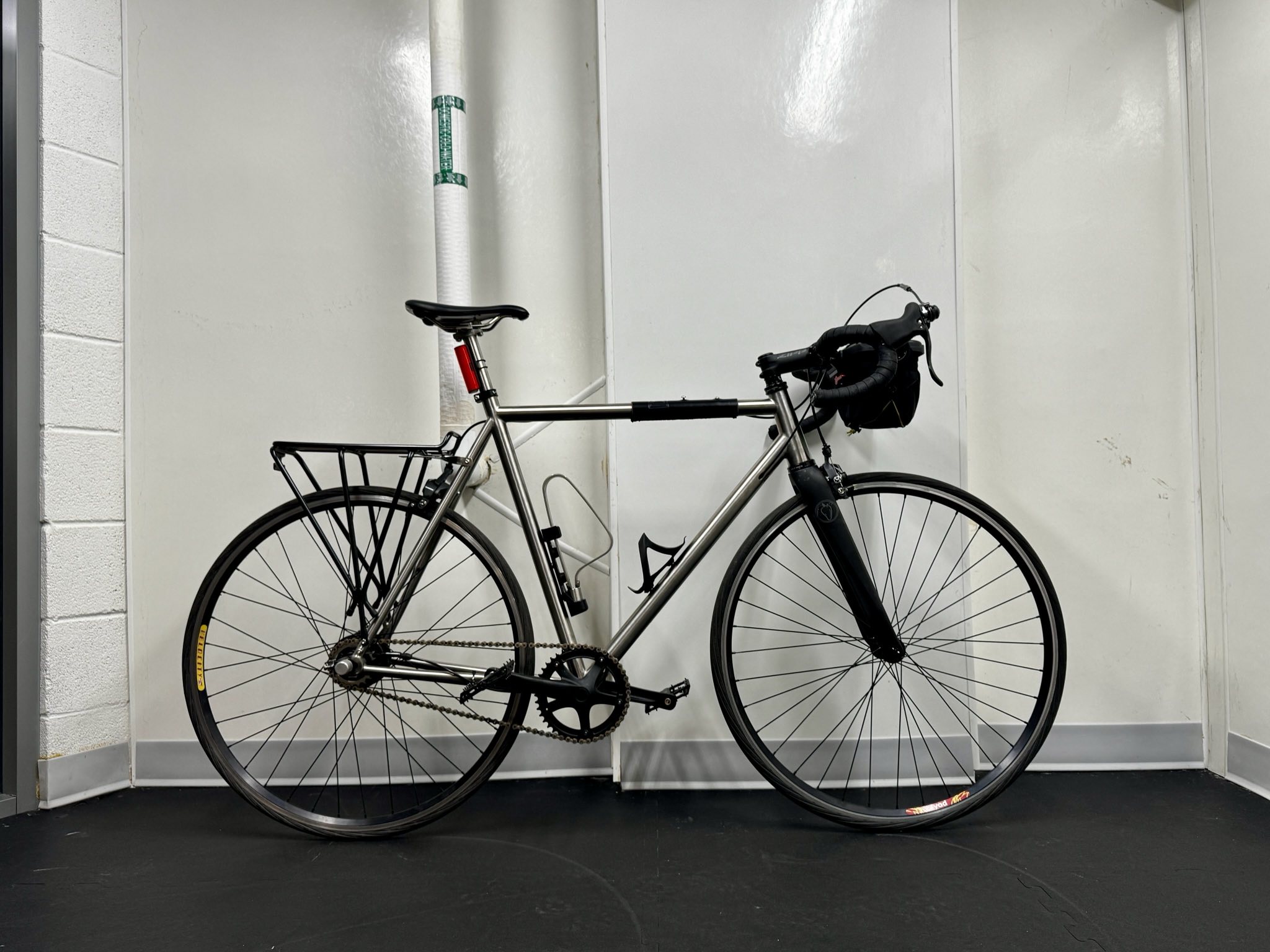 the bike in a bike maintenance garage, leaning against a wall