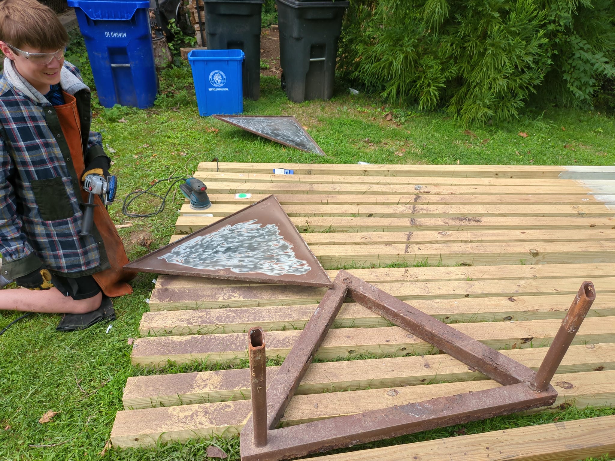 the steel frame elements being stripped of paint with an angle grinder and an abrasive disc